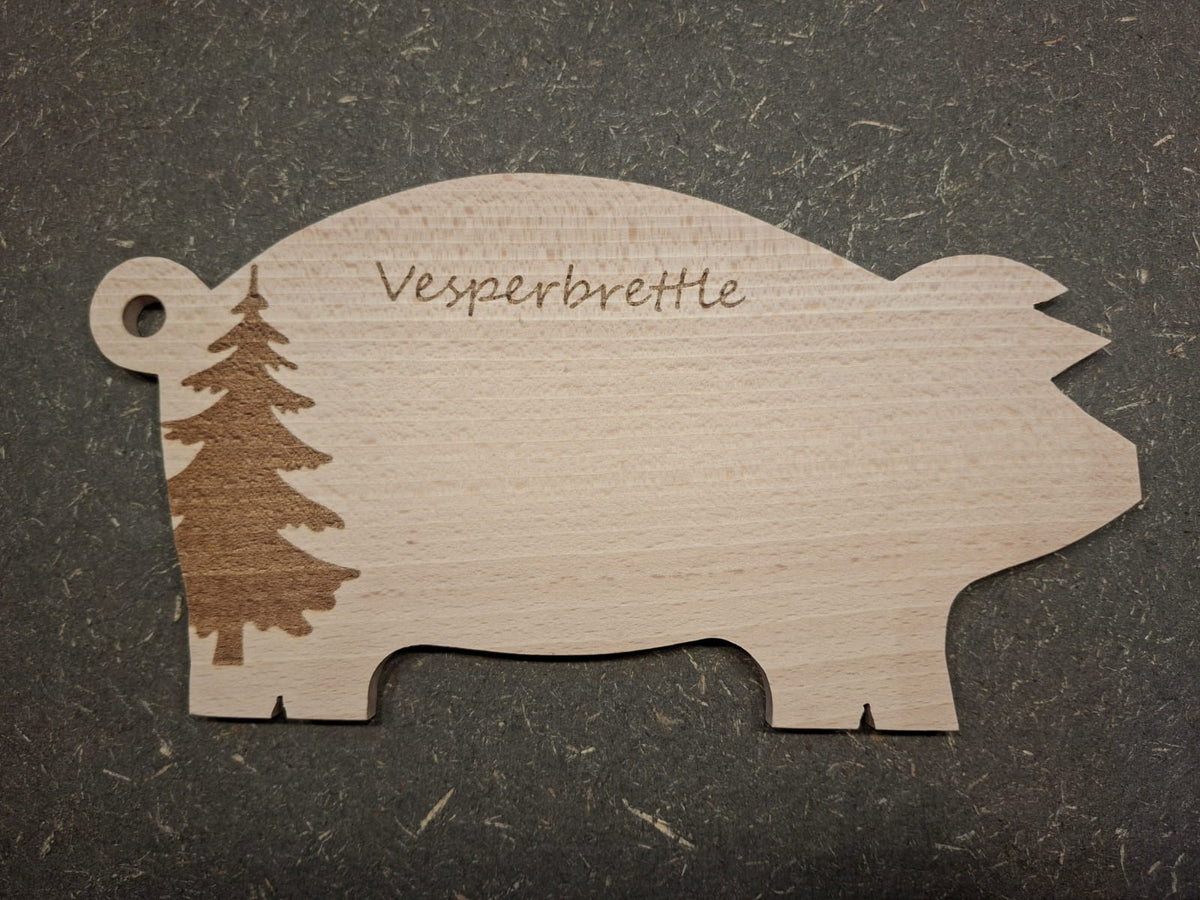 Handgefertigte Servierplatte und Vesperbrett in Schweinchenform aus massivem Buchenholz. Mit Tannenbaum Gravur.