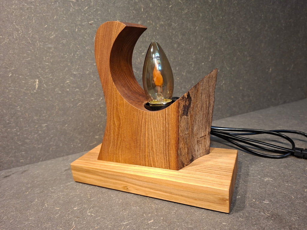 Handgefertigte Holzlampe Flammenzauber aus Walnuss und Esche mit warm flackerndem Licht in Flammenoptik. Lampe mit Rinde.