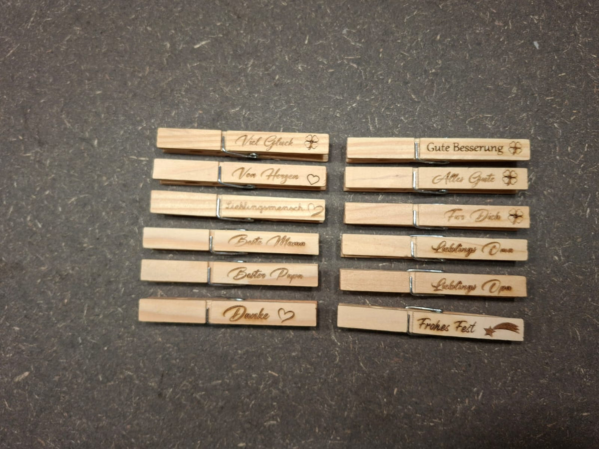 Holzklammer aus Holz mit verschiedenen gravierten Sprüchen.