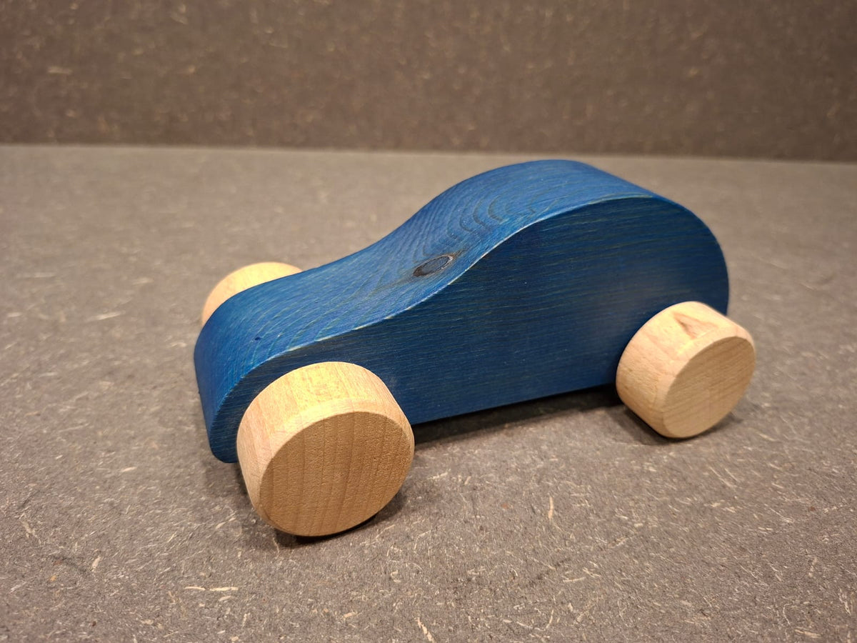 Handgefertigtes Holzauto aus Fichtenholz mit drehbaren Buchenholzrädern für Kleinkinder.
Blau.