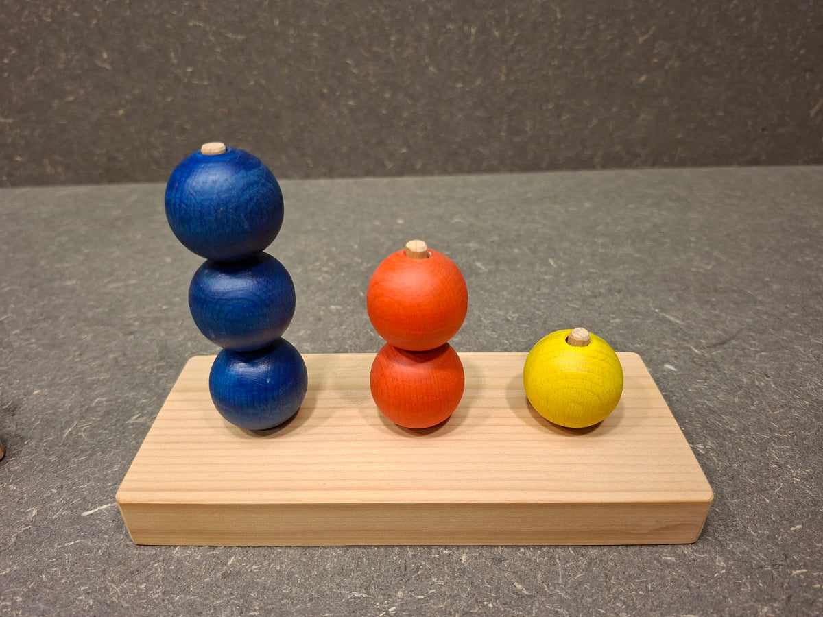 Handgefertigtes Steckspiel aus Fichten- und Buchenholz mit bunten Kugeln für Kleinkinder.