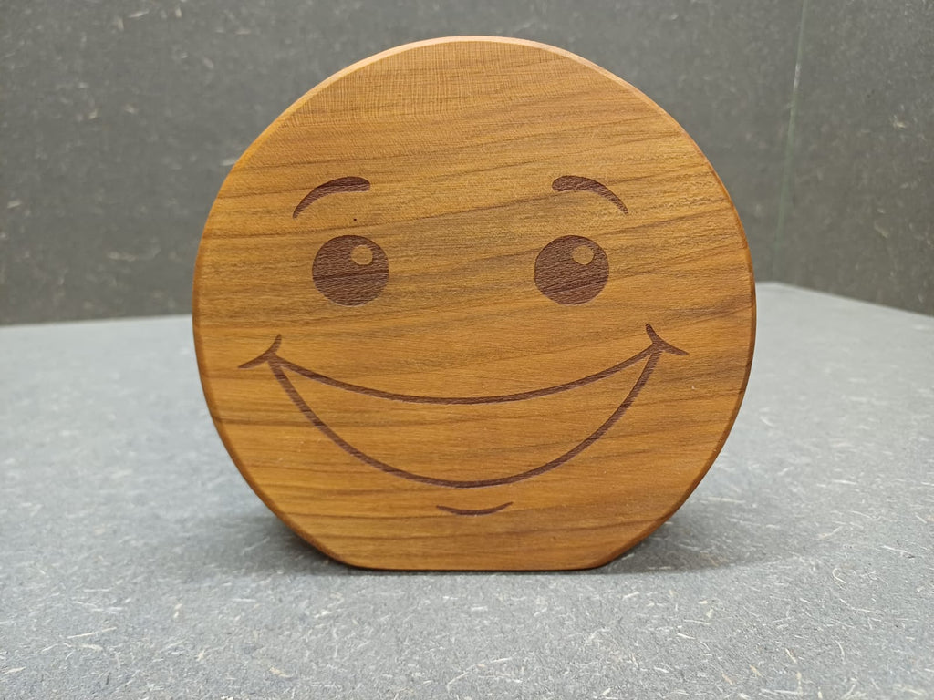 Handgefertigter Smiley aus Holz mit graviertem Gesicht und natürlicher Holzmaserung als dekorativer Holzaufsteller.