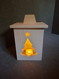 Drei handgefertigte LED-Weihnachtslaternen aus hellem Holz mit ausgesägten Motiven Weihnachtsmann, Tannenbaum und Kerze. Tannenbaum beleuchtet.