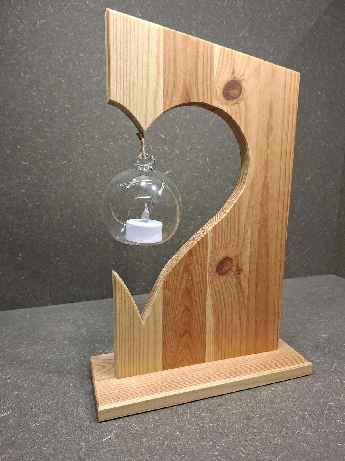 Handgefertigte Holzdekoration aus Fichte mit schwebender Glaskugel und LED-Kerze.