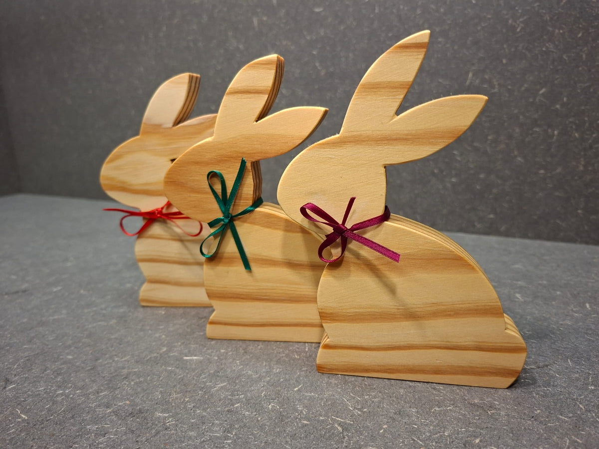Handgefertigter Hase aus geölter Kiefer mit Schleife als natürliche Osterdekoration.