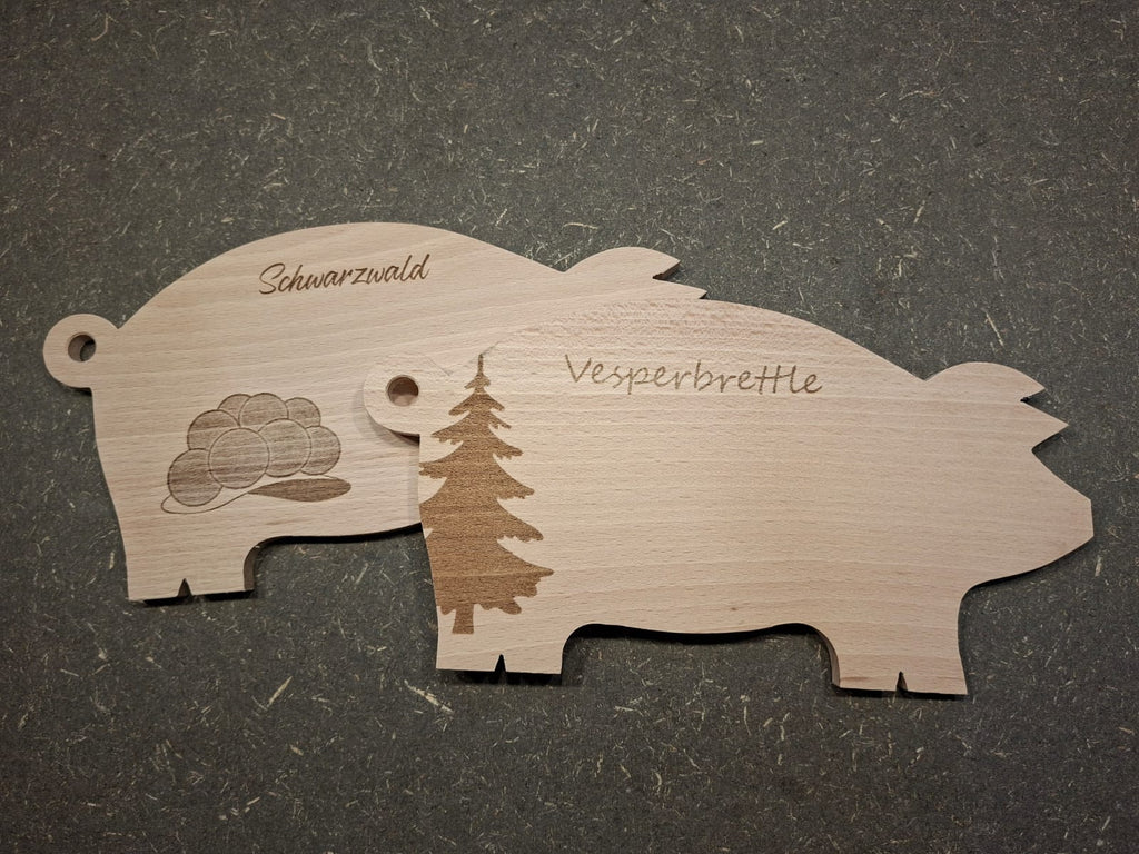 Handgefertigte Servierplatte und Vesperbrett in Schweinchenform aus massivem Buchenholz. Verschiedene Gravuren auf einem Bild.