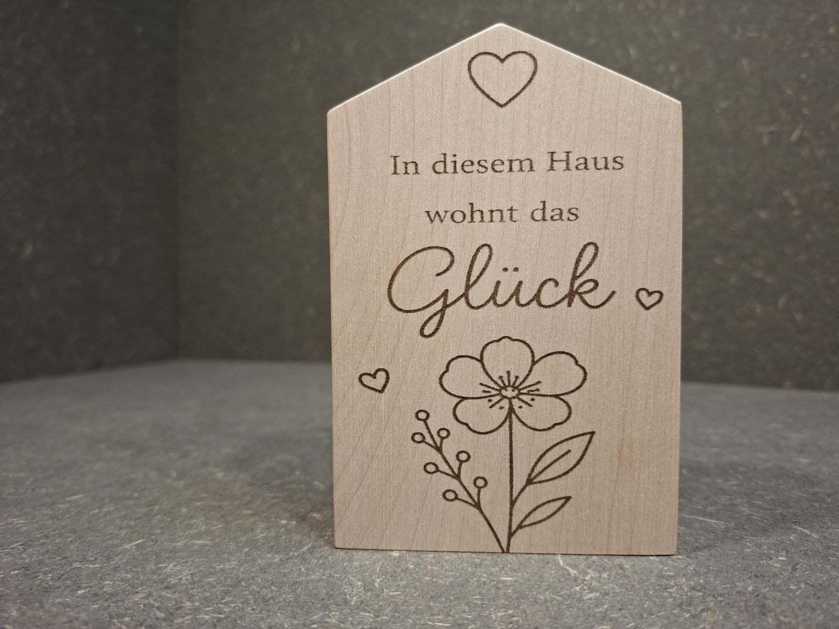 Dekohaus aus Ahornholz. In diesem Haus wohnt das Glück. Blume mittig unten auf dem Haus.