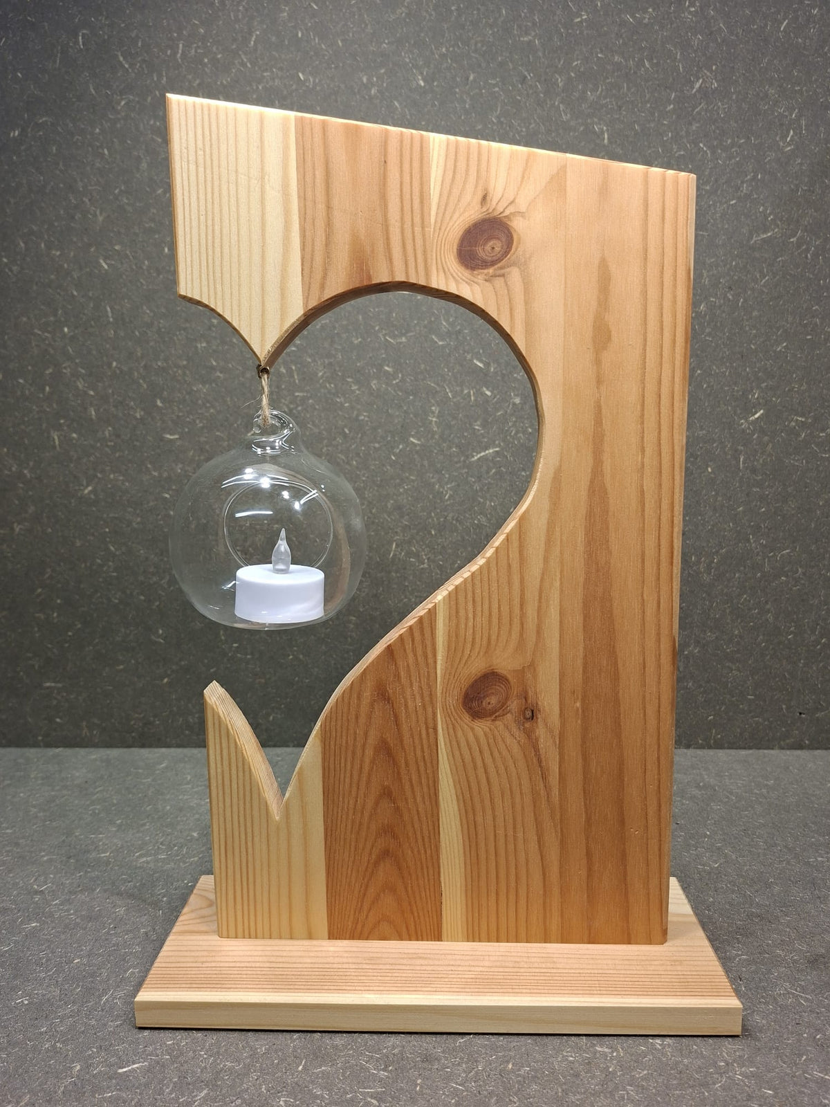 Handgefertigte Holzdekoration aus Fichte mit schwebender Glaskugel und LED-Kerze.