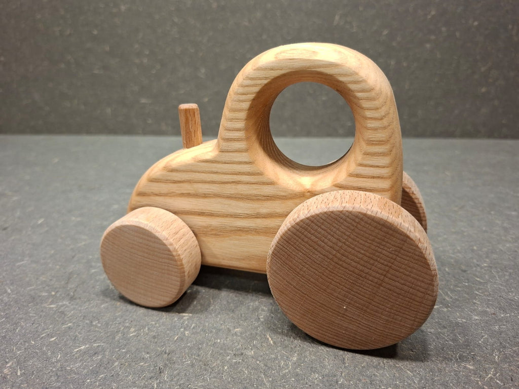 Handgefertigter Holztraktor aus massivem Eschenholz mit natürlicher Holzmaserung.