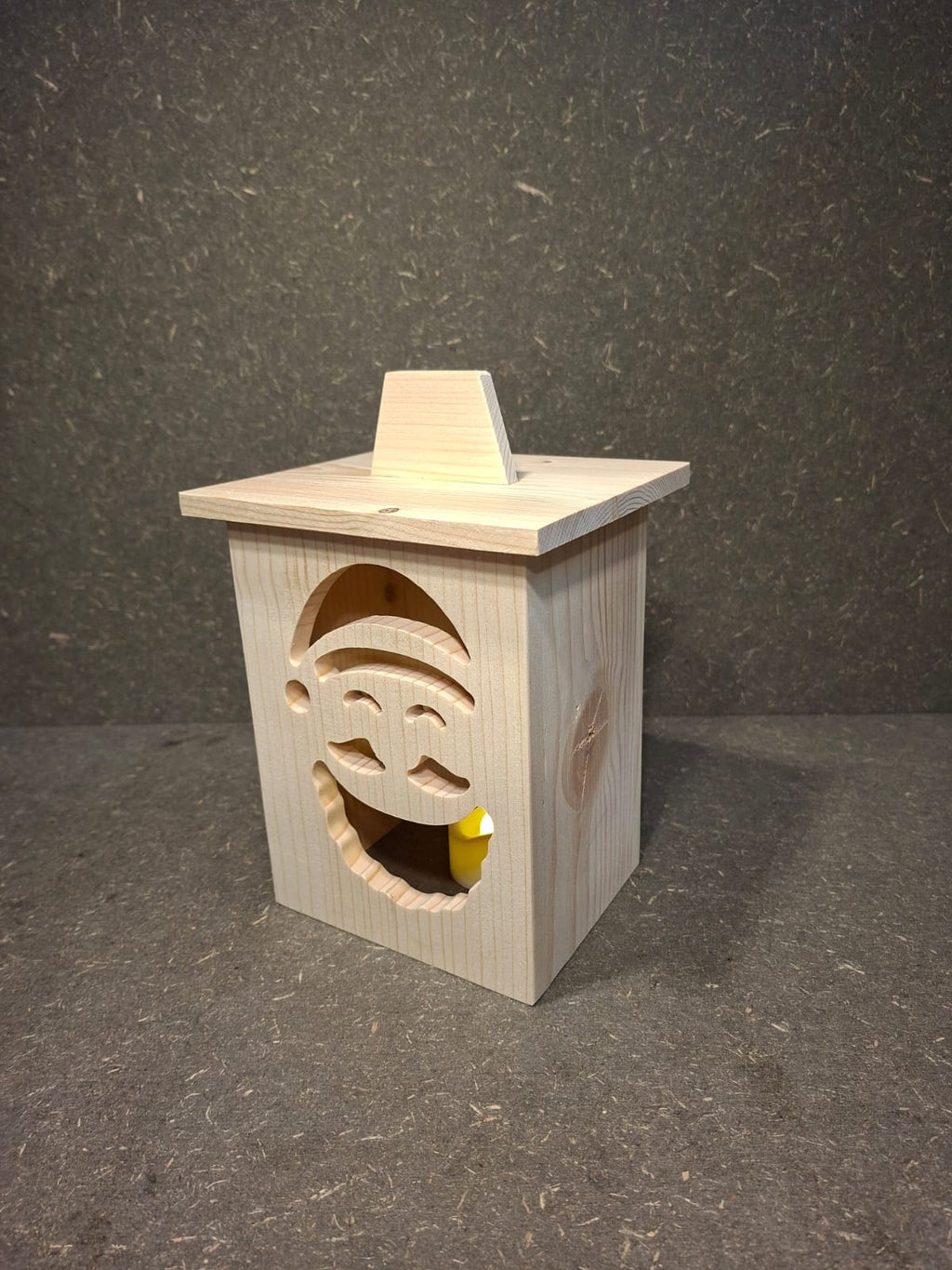 Drei handgefertigte LED-Weihnachtslaternen aus hellem Holz mit ausgesägten Motiven Weihnachtsmann, Tannenbaum und Kerze.