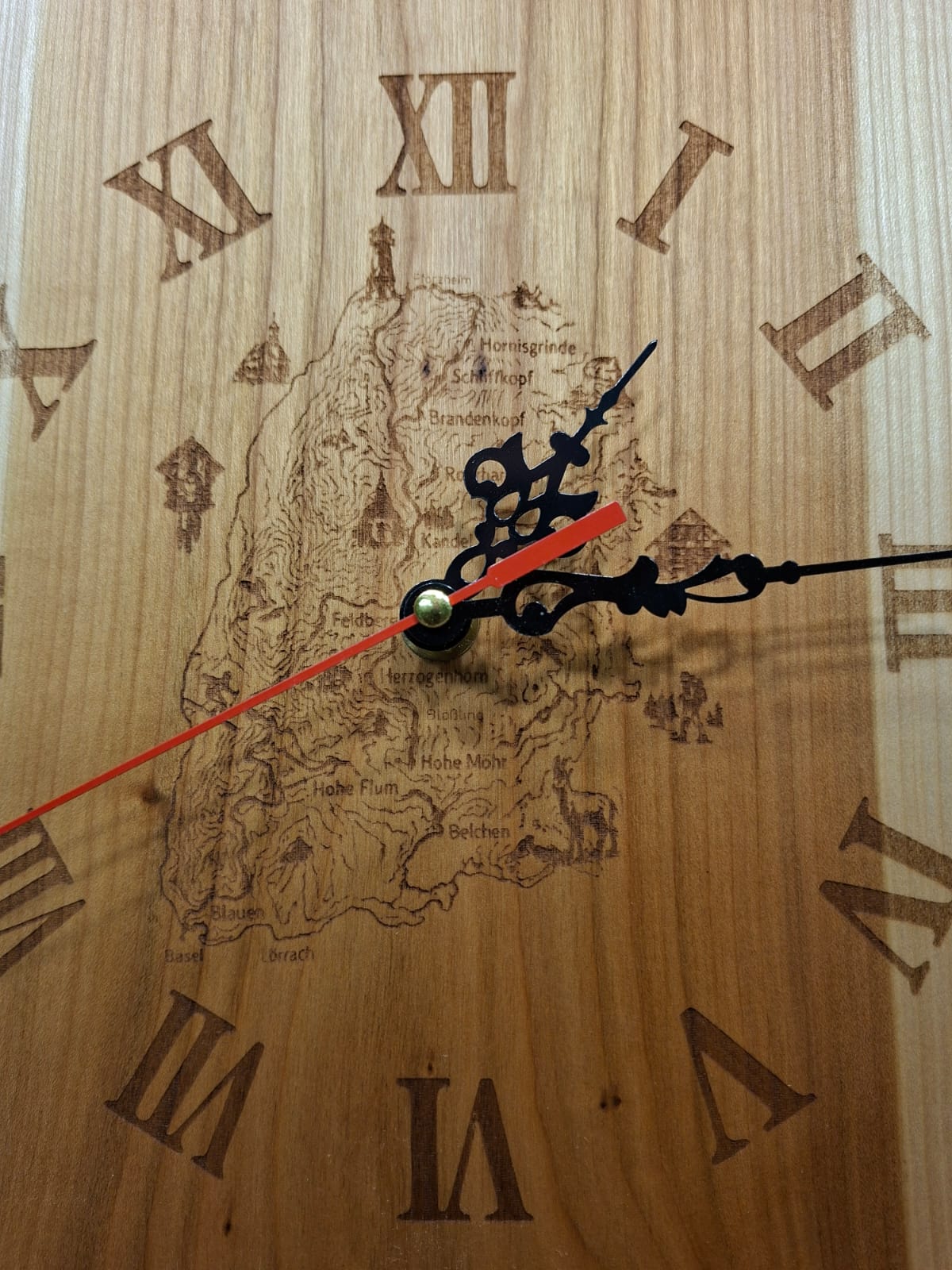 Handgefertigte Wanduhr aus geöltem Kirschholz mit Gravur des Westwegs und der Schwarzwaldberge.