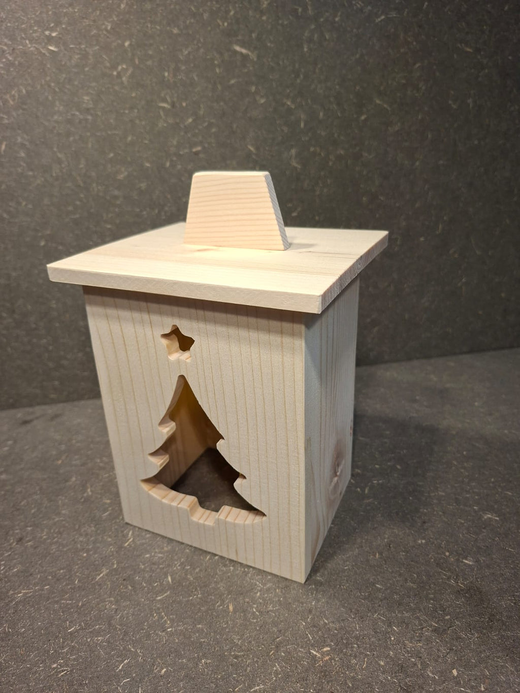 Drei handgefertigte LED-Weihnachtslaternen aus hellem Holz mit ausgesägten Motiven Weihnachtsmann, Tannenbaum und Kerze.