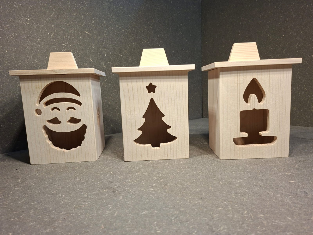 Drei handgefertigte LED-Weihnachtslaternen aus hellem Holz mit ausgesägten Motiven Weihnachtsmann, Tannenbaum und Kerze.