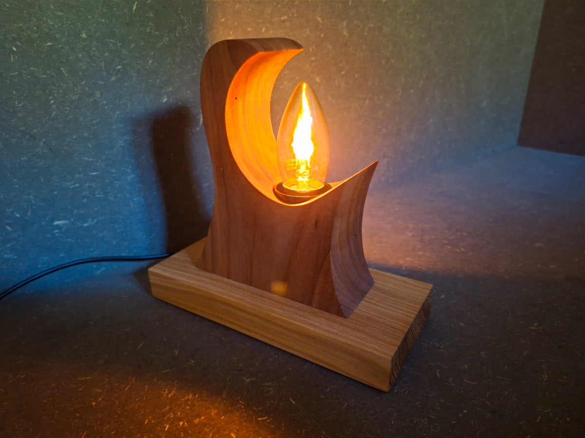 Handgefertigte Holzlampe Flammenzauber aus Walnuss und Esche mit warm flackerndem Licht in Flammenoptik. Lampe ohne Rinde.