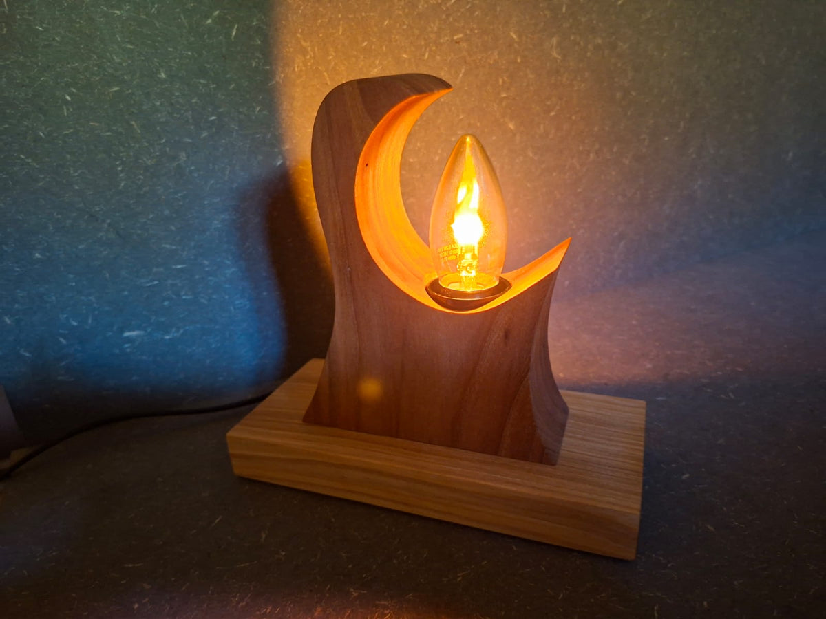 Handgefertigte Holzlampe Flammenzauber aus Walnuss und Esche mit warm flackerndem Licht in Flammenoptik. Lampe ohne Rinde.