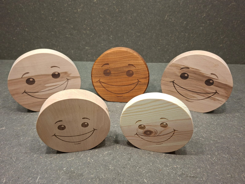 Handgefertigter Smiley aus Holz mit graviertem Gesicht und natürlicher Holzmaserung als dekorativer Holzaufsteller.