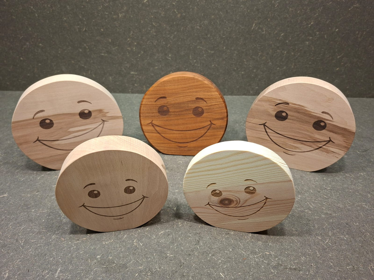 Handgefertigter Smiley aus Holz mit graviertem Gesicht und natürlicher Holzmaserung als dekorativer Holzaufsteller.