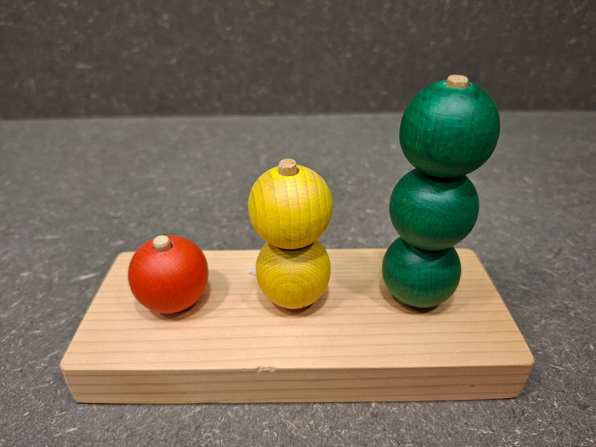 Handgefertigtes Steckspiel aus Fichten- und Buchenholz mit bunten Kugeln für Kleinkinder.