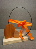 Handgefertigte Osterei-Dekoration aus Esche und Kirsche mit filigranem Metallei als stilvolle Osterdekoration. Schleife Orange 
