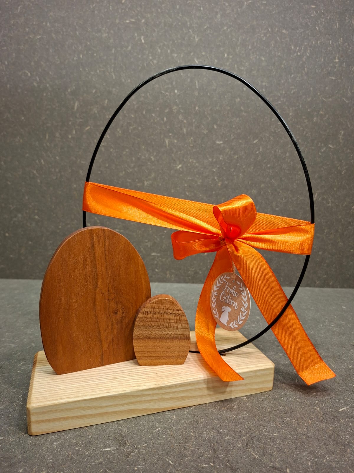 Handgefertigte Osterei-Dekoration aus Esche und Kirsche mit filigranem Metallei als stilvolle Osterdekoration. Schleife Orange 
