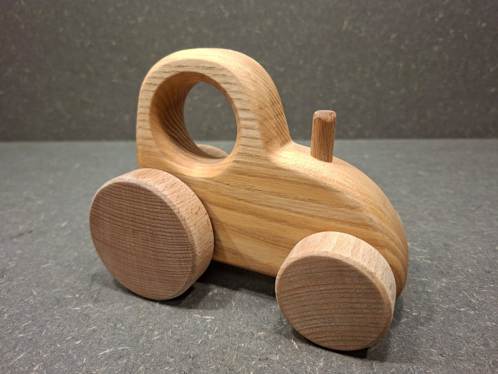 Handgefertigter Holztraktor aus massivem Eschenholz mit natürlicher Holzmaserung.