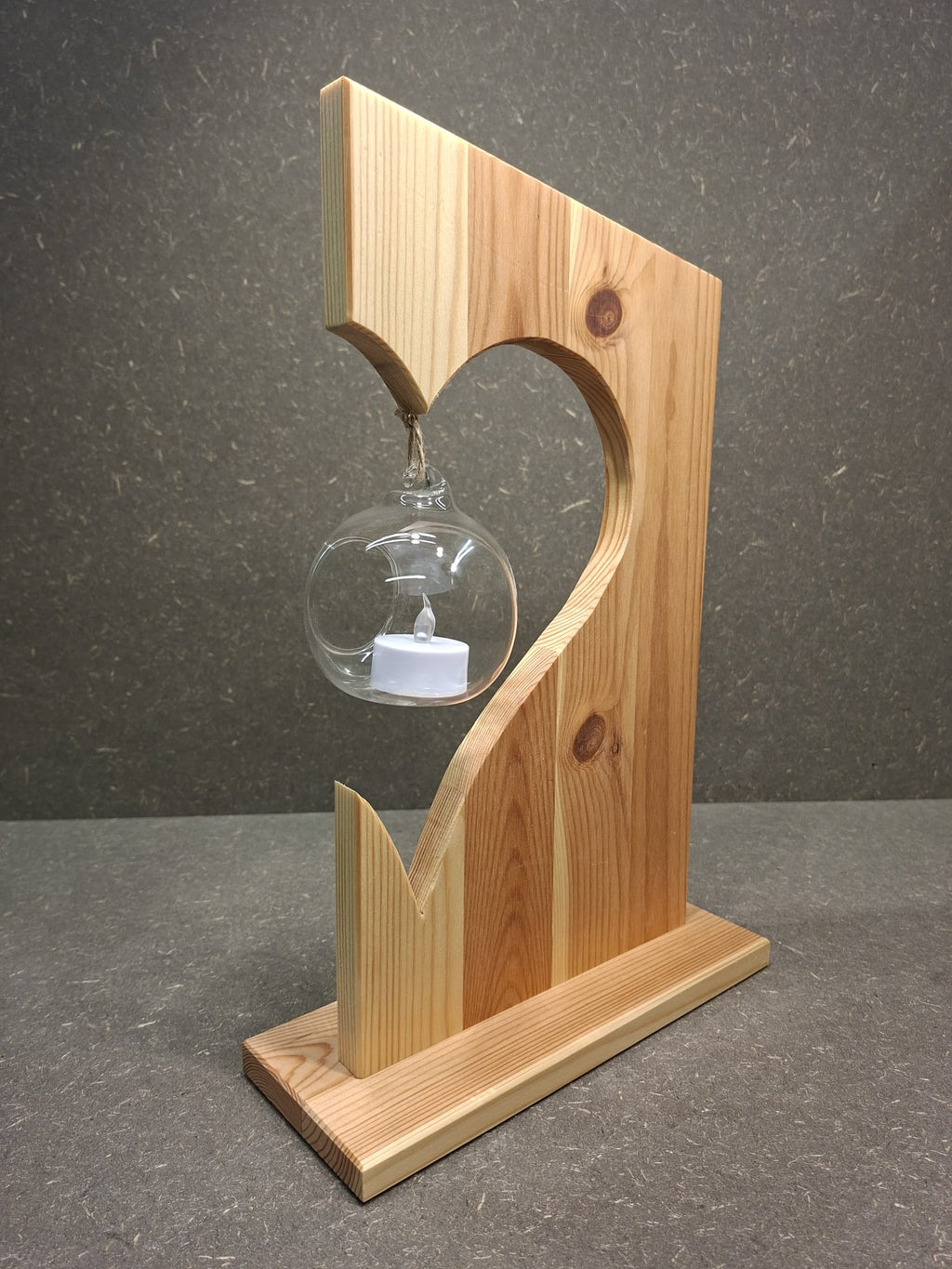 Handgefertigte Holzdekoration aus Fichte mit schwebender Glaskugel und LED-Kerze.