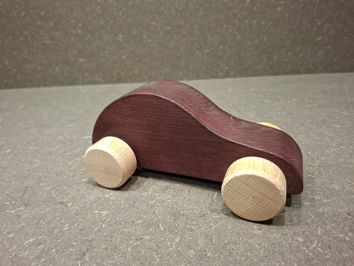 Handgefertigtes Holzauto aus Fichtenholz mit drehbaren Buchenholzrädern für Kleinkinder.
Lila.