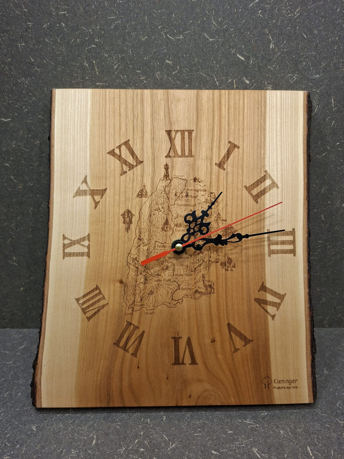 Handgefertigte Wanduhr aus geöltem Kirschholz mit Gravur des Westwegs und der Schwarzwaldberge.
