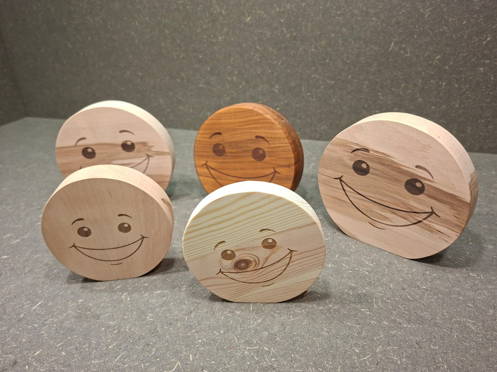 Handgefertigter Smiley aus Holz mit graviertem Gesicht und natürlicher Holzmaserung als dekorativer Holzaufsteller.