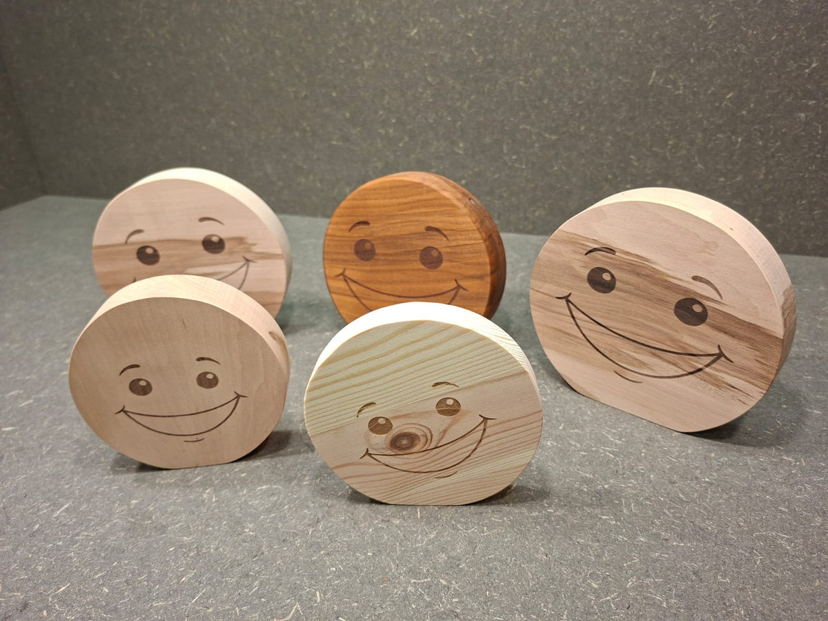 Handgefertigter Smiley aus Holz mit graviertem Gesicht und natürlicher Holzmaserung als dekorativer Holzaufsteller.