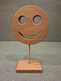 Handgefertigter Holz Smiley aus geöltem Birnenholz mit Holzstab und Standfuß als natürliche Dekoration.