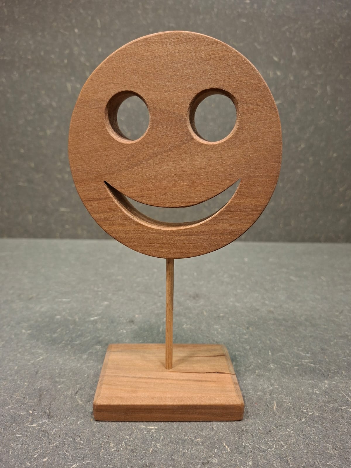 Handgefertigter Holz Smiley aus geöltem Birnenholz mit Holzstab und Standfuß als natürliche Dekoration.