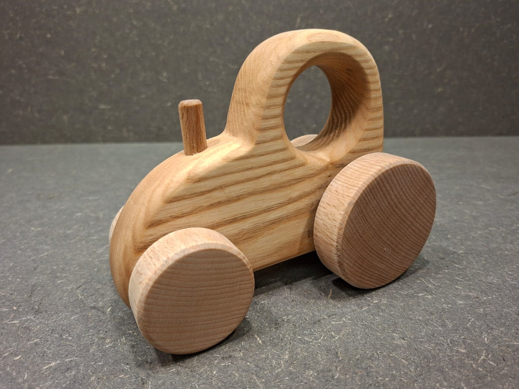 Handgefertigter Holztraktor aus massivem Eschenholz mit natürlicher Holzmaserung.