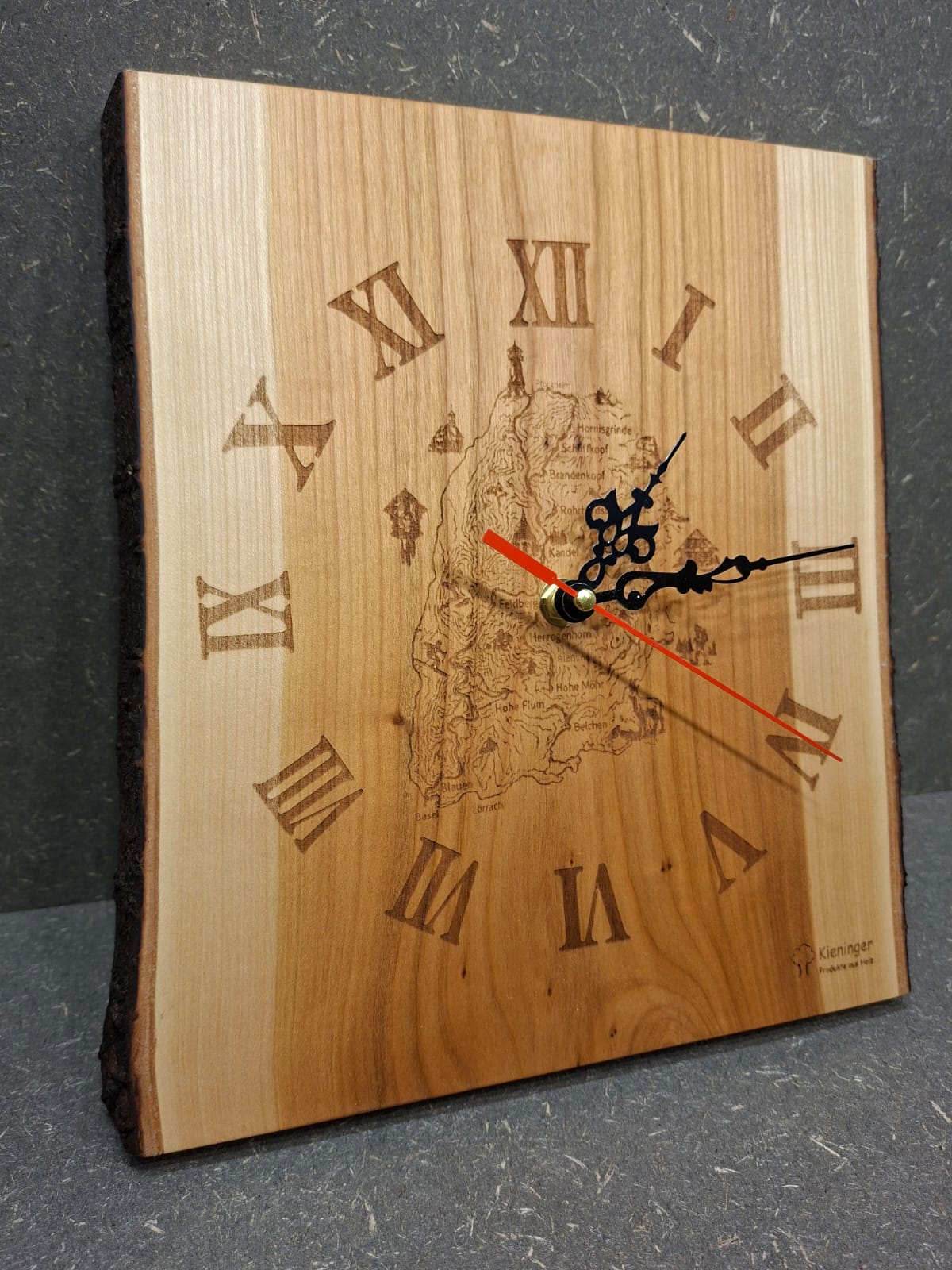 Handgefertigte Wanduhr aus geöltem Kirschholz mit Gravur des Westwegs und der Schwarzwaldberge.