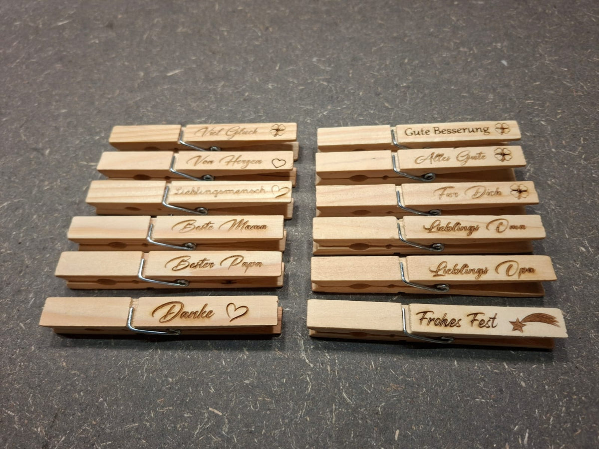 Holzklammer aus Holz mit verschiedenen gravierten Sprüchen.