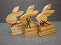 Handgefertigter Hase aus geölter Kiefer mit Schleife als natürliche Osterdekoration.
